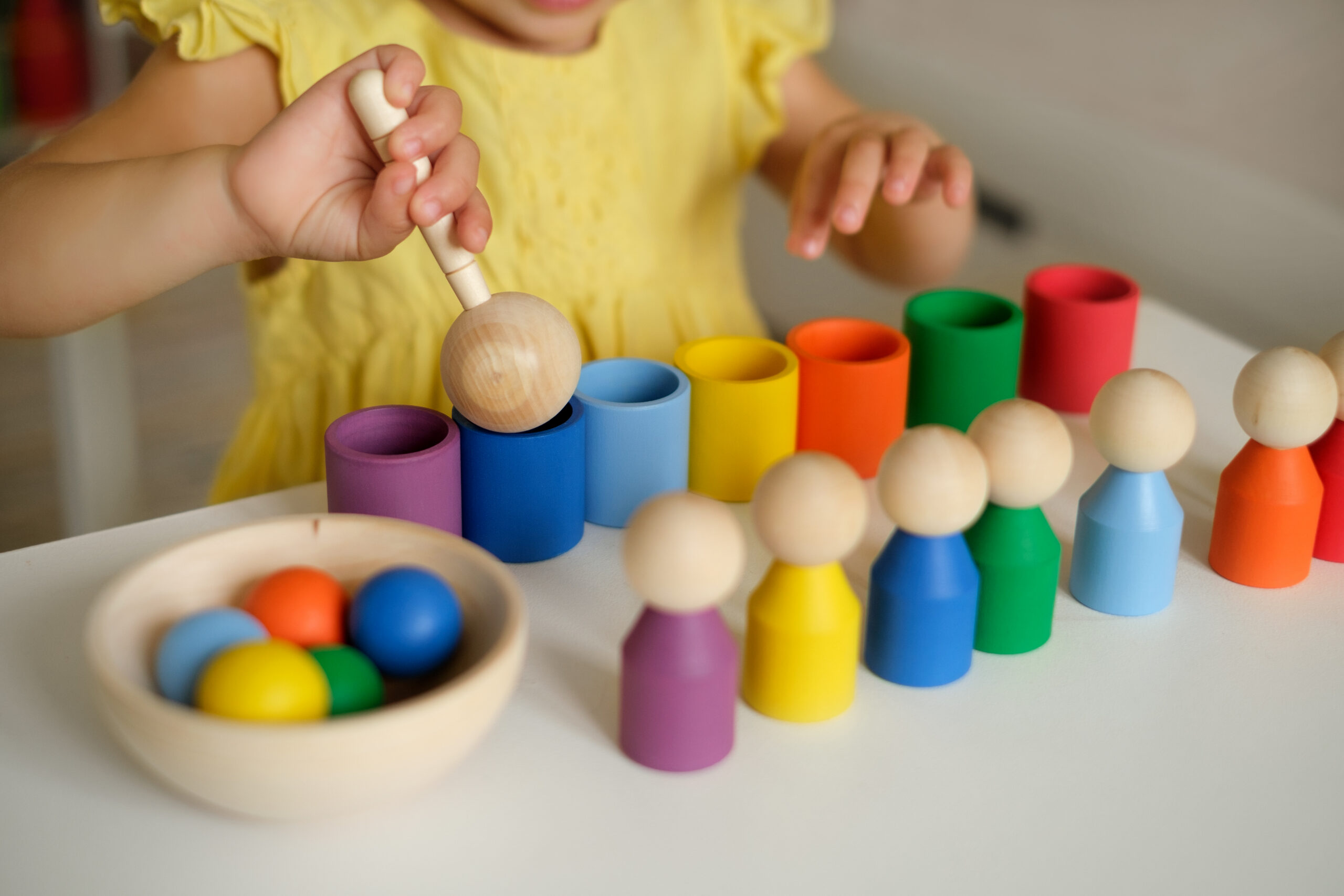 Un enfant joue avec un jeu de tri en bois coloré